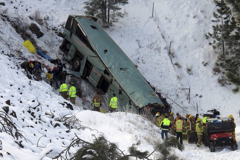 Emergency personnel respond to the scene of a multiple-fatality accident after a tour bus careened through a guardrail along an icy highway and fell several hundred feet down a steep embankment Sunday about 15 miles east of Pendleton, Ore.