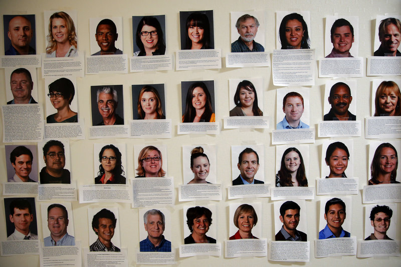 Photos of some of the newly hired reporters at the Orange County Register line the newsroom wall. About 75 new journalists have been added with more on the way.