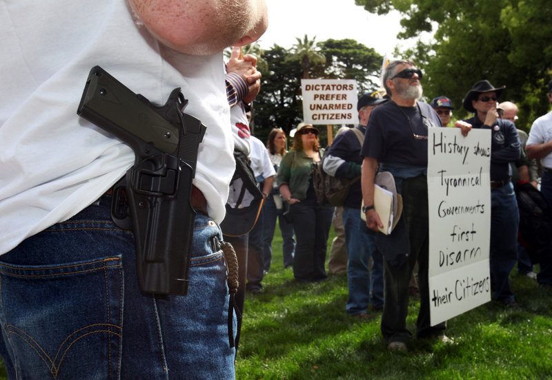 A gun owner wears a holstered, unloaded pistol at a Second Amendment rally in Sacramento, Calif., in 2010. The ambiguous wording of the amendment has sowed confusion regarding firearm regulation, readers say.