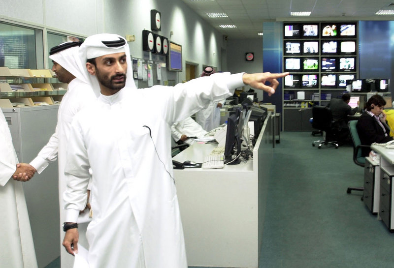 A Qatari staff member of al-Jazeera points out the newsroom of the TV network in Doha, Qatar, in February 2005.