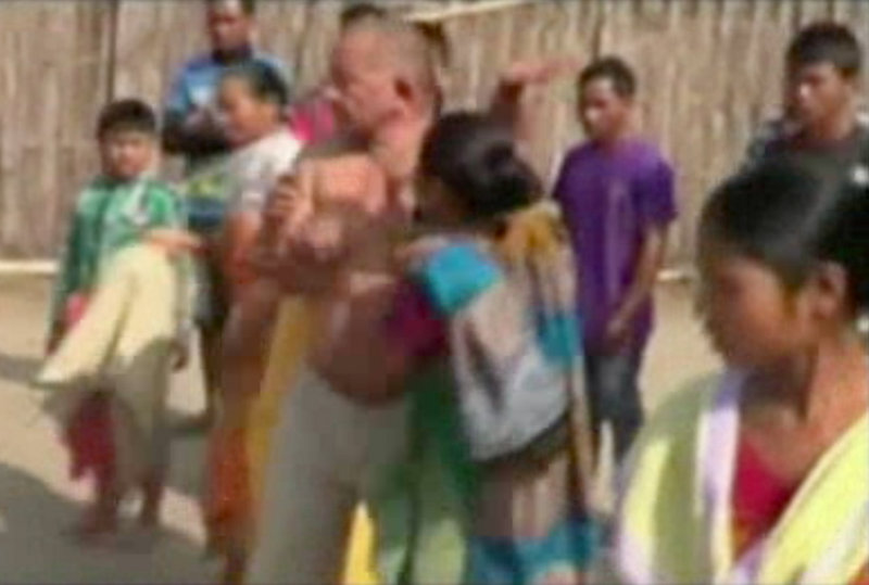 Bikram Singh Brahma, center, a leader of India’s ruling Congress party, is slapped by a woman in the village of Santipur, India, on Thursday. Police said he was visiting the village when he entered a woman’s house at 2 a.m. and raped her.