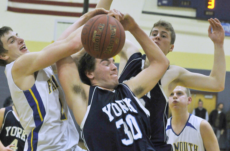 Luke Claflin, right, of York battles for a rebound with Falmouth’s Charlie Fay in Thursday’s boys’ basketball game at Falmouth. The Yachtsmen stayed unbeaten by knocking off the previously perfect Wildcats by 20 points.