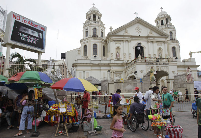 “No to abortion” flashes on an electric sign outside the Minor Basilica of the Black Nazarene in Manila on Thursday. Catholic leaders consider the new law that provides state funding for contraceptives an attack on the church’s core values.