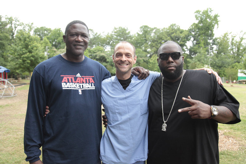 Dominique Wilkins, an NBA Hall of Famer who is considered one of the best dunkers of all times, left, Dr. Kevin Strong, founder of Dunk the Junk, and rap artist Killer Mike attend the Dunk the Junk event at the Emma Hutchinson Elementary School in Atlanta.
