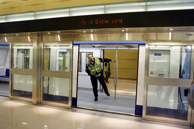 A worker looks out of a train car and through the open doorway of the glass security barrier at Washington Dulles International Airport. New York City is considering similar safety barriers after three people died on the tracks recently.
