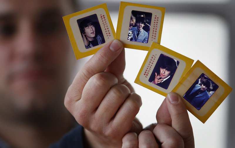 Auctioneer Paul Fairweather holds slides of The Beatles taken during their first tour of the United States in 1964. The rare color transparencies, taken by Dr. Robert Beck, are to be sold at Omega Auctions in Stockport, England, in March.