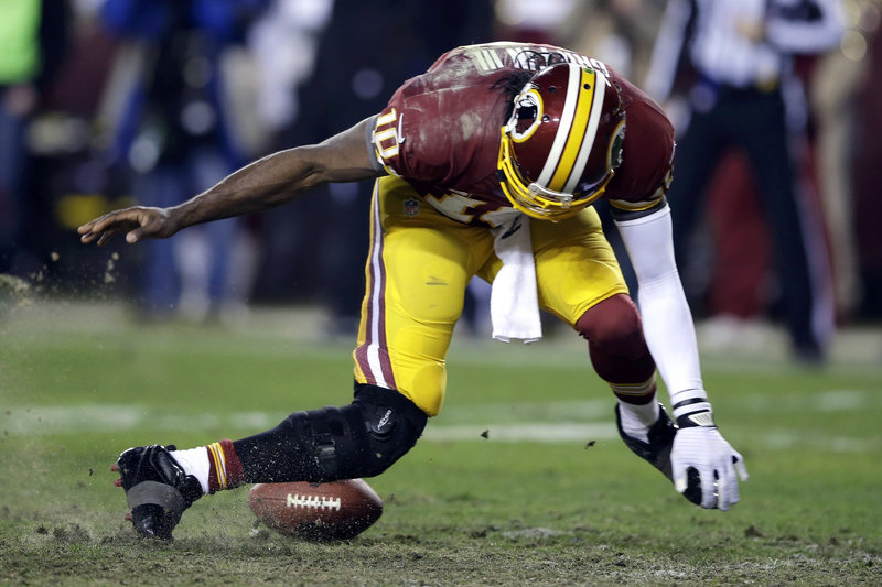 Robert Griffin III’s right leg bends awkwardly as he tries to scoop up an errant snap in the fourth quarter. Griffin left the game and didn’t return.
