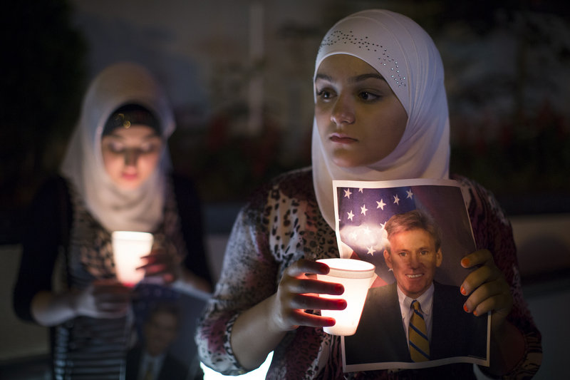 A girl holds a photo of slain U.S. Ambassador to Libya Christopher Stevens at a vigil outside the Libyan Embassy in New York on Sept. 13. When Stevens was killed, Republicans soon doled out blame, but following the Newtown massacre, conservatives said that talk of new limits on firearms was an effort “to ‘capitalize on a tragedy,’” a reader says.