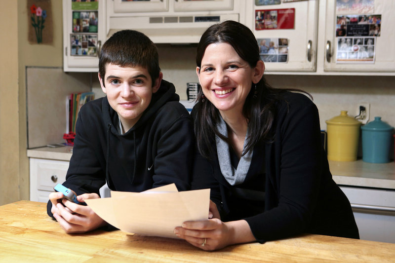 Janell Burley Hofmann is pictured with her son Gregory at their Sandwich, Mass., home. She holds a contract she drafted and Gregory signed as a condition for receiving his first Apple iPhone.