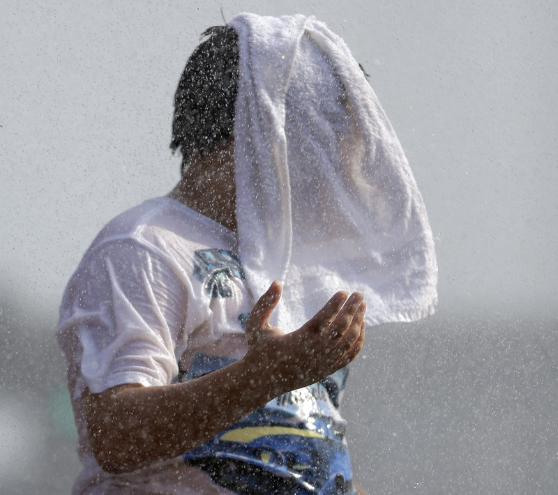 Timmy Benson wears a wet towel as he cools off in a fountain before a Cardinals game in St. Louis last July 6. Federal meteorologists say the average U.S. temperature in 2012 was 55.32 degrees, 1 degree warmer than the previous record of 1998. Normally, records are broken by about a tenth of a degree.