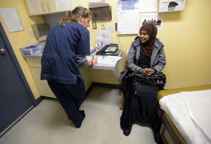 Staff Photo by Shawn Patrick Ouellette: Medical assistant Anissa Millette talks with Leila Hassan of Portland before giving her a flu shot at Portland Community Health Center Thursday, Jan. 10, 2013.