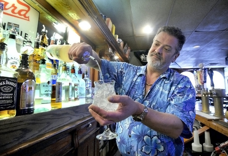 Bartender Doug Johnson pours a mango rum on the rocks at Pizza Villa in Portland.