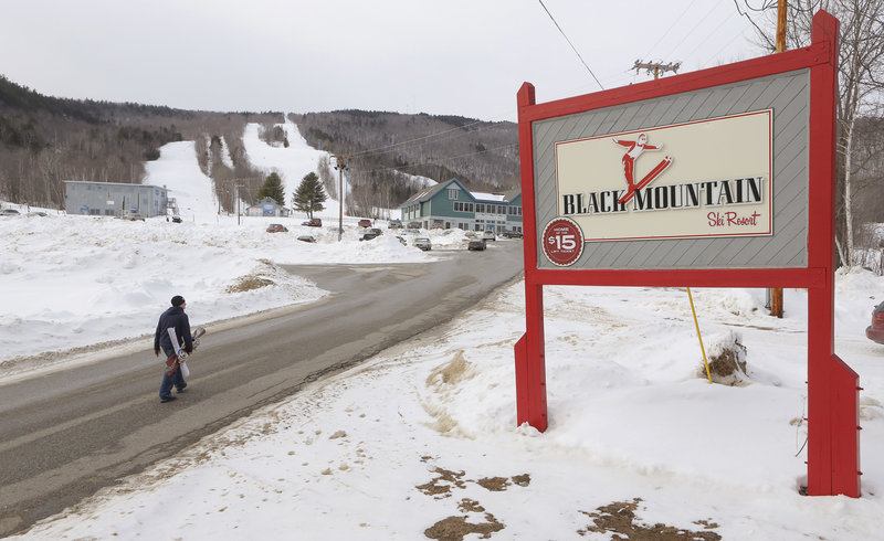 A snowboarder walks up the main access road to Black Mountain, long a local attaction that now is marketing itself for an expanded clientele.