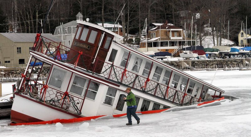 Owner of the MV Kearsarge, Peter Fenton, examines his sinking dinner cruise ship in Sunapee Harbor Friday, Jan. 11, 2013 in Sunapee, N.H. Authorities said the ship started to go under at about 7:45 p.m. Thursday, and part of the lower deck at the back of the boat was under water Friday morning. It was not immediately known what caused the problem. The MV Kearsarge has been taking visitors around Lake Sunapee from May through October for over 30 years.