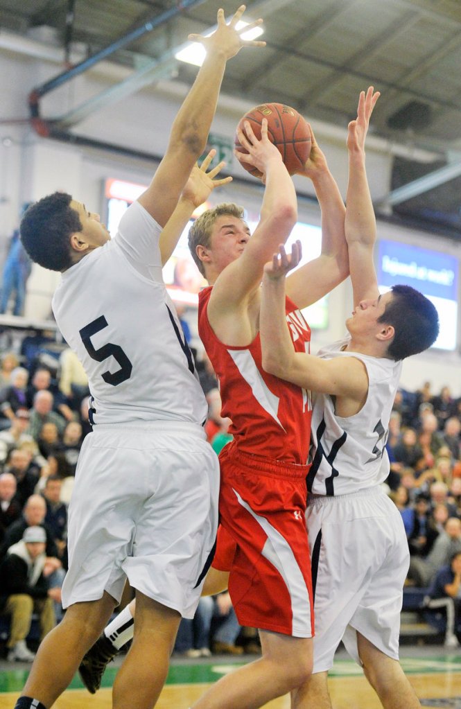 Ben Burkey of South Portland attempts to get off a shot Friday night while defended by Matt Talbot, left, and Justin Zukowski of Portland at the Expo.