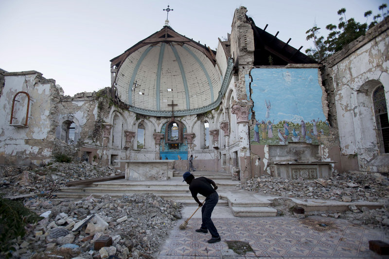 A man sweeps an exposed tiled area of the earthquake-damaged Santa Ana Catholic church, where he now lives, in Port-au-Prince, Haiti, on Saturday. Haitians recalled Saturday the tens of thousands of people who lost their lives in the devastating 2010 earthquake. More than 350,000 people still live in displacement camps.