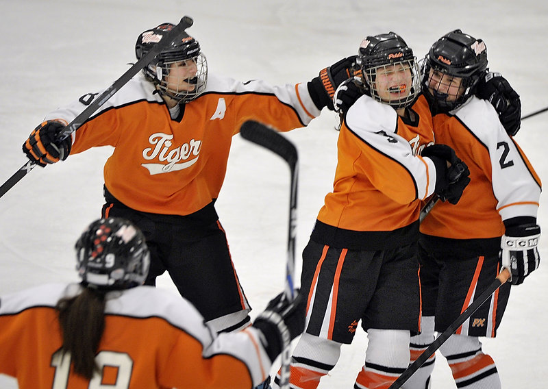 Celebrating a goal for Biddeford are assistant captain Dalani Roy, left, along with Brea Rivard hugging Abbie Paquette, right.