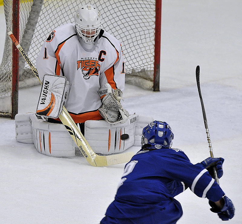 Biddeford goalie Jon Fields holds his ground and stops a shot by Evan Gosselin of Lewiston during Lewiston’s 3-1 victory Saturday at Biddeford Ice Arena. Fields came up with 40 saves.