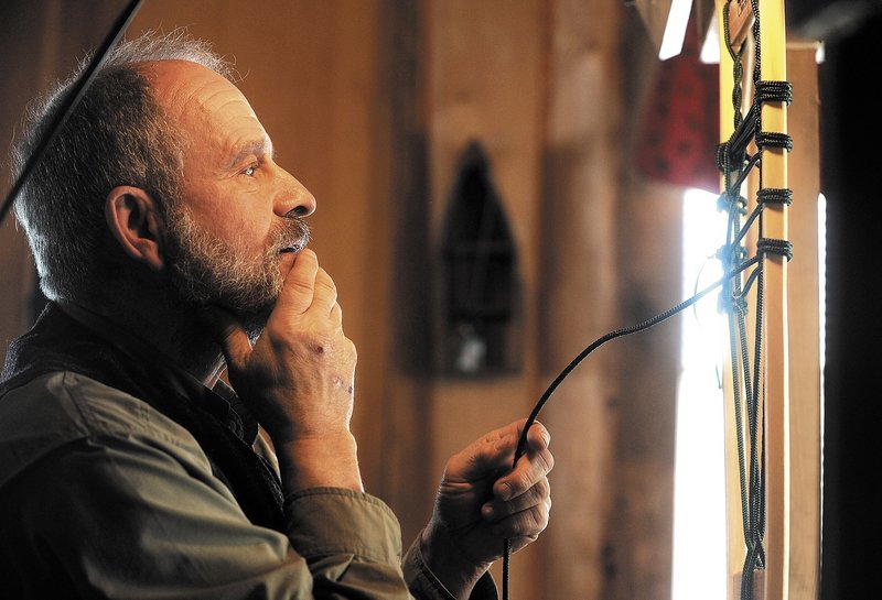 Dave Giampetruzzi laces a one-of-a-kind snowshoe in his cabin at Pine Grove Lodge.