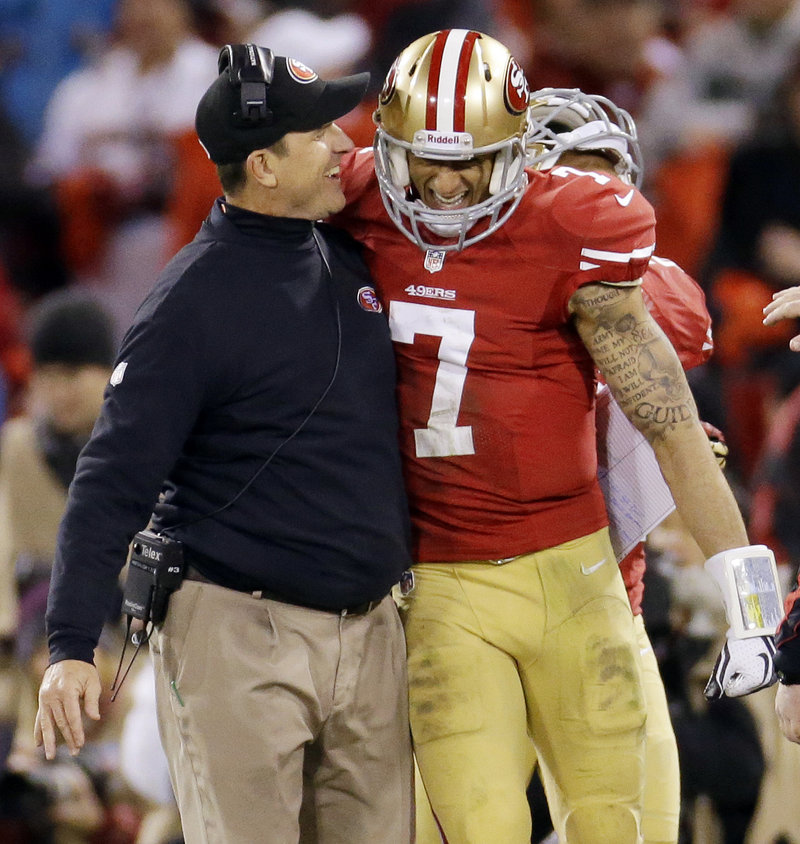 San Francisco Coach Jim Harbaugh celebrates with Colin Kaepernick after the quarterback’s 56-yard touchdown run against the Green Bay Packers during the third quarter of Saturday’s game, won by San Francisco.