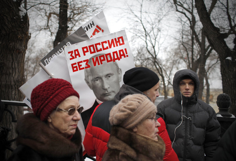 A poster of Russian President Vladimir Putin with the words “For a Russia without Herod!” is seen Sunday at a Moscow rally against a law barring Americans from adopting Russian children. The biblical ruler Herod ordered the massacre of infants in Bethlehem at the time of Jesus.