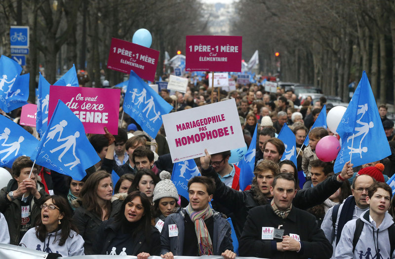 Critics of President Francois Hollande’s same-sex marriage and adoption proposal converge on Paris on Sunday. The protest was believed to be one of the largest in the city since 1984. The placard in the middle reads, “Pro-marriage, not anti-gay.”