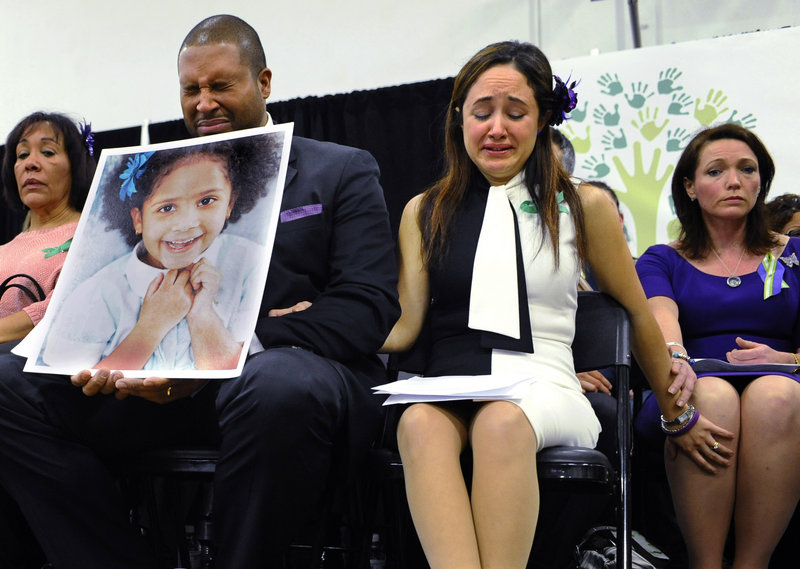 Jimmy Greene, foreground left, Nelba Marquez-Greene, center, parents of Sandy Hook shooting victim Ana Marquez-Greene, and Nicole Hockley, right, mother of victim Dylan Hockley, react during a Monday news conference in Newtown, Conn.