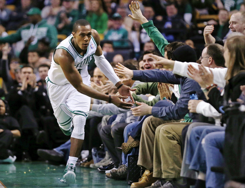 Boston’s Rajon Rondo has courtside supporters with high-fives at the ready after he scored two of his 17 points during the Celtics’ 100-89 win at Boston on Monday.