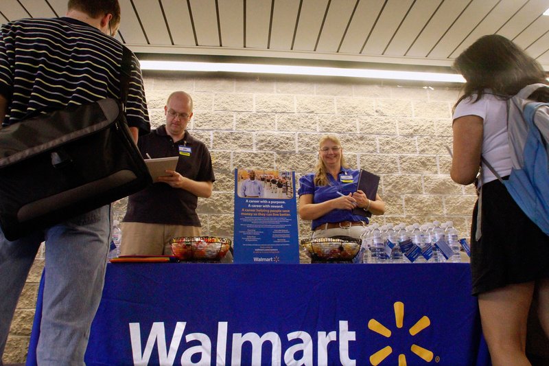 Walmart employees Jon Christians and Lori Harris take applications during a job fair at the University of Illinois Springfield campus. The nation’s largest private employer pledged Tuesday to hire more than 100,000 veterans.