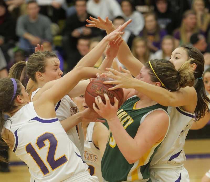 Victoria Lux of McAuley controls the ball Tuesday night among Cheverus defenders, including Jill Libby, 12, and Jess Willerson, right. McAuley won, 51-30.