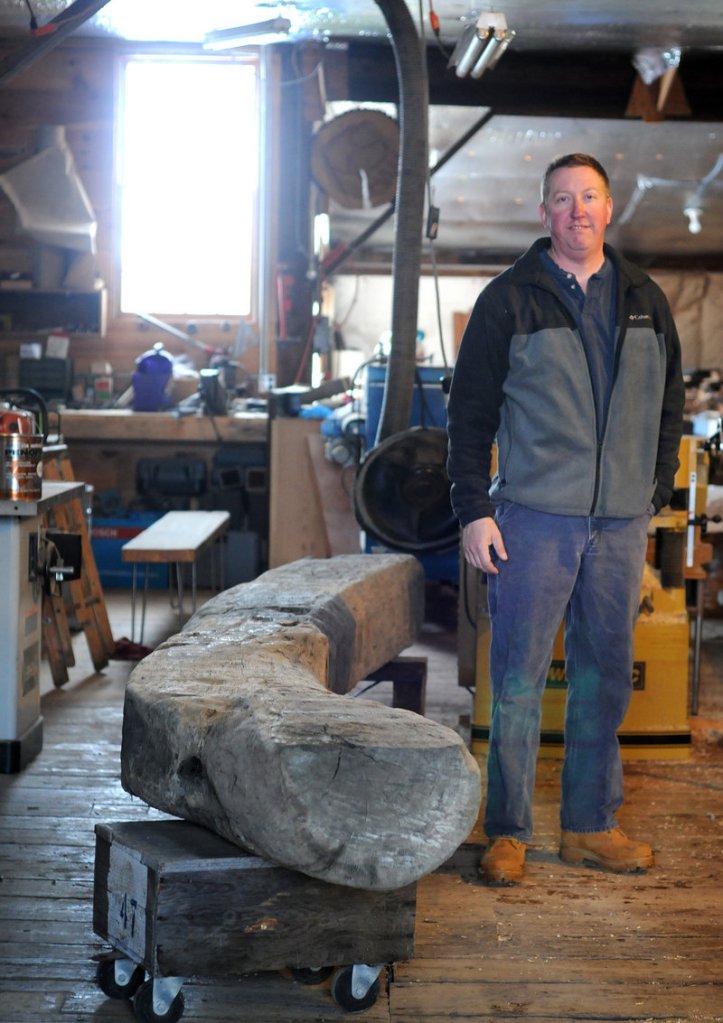 In this Jan. 4, 2013 photo, Tom Mann, of T.S. Mann Lumber, stands near a 300 year old oak beam at his shop in Athol, Mass. The beam was dug up near Boston Harbor where the Spaulding Rehab Center is being built. Mann has been commissioned to create a bench for the center. (AP Photo/Worcester Telegram & Gazette, Tom Rettig)