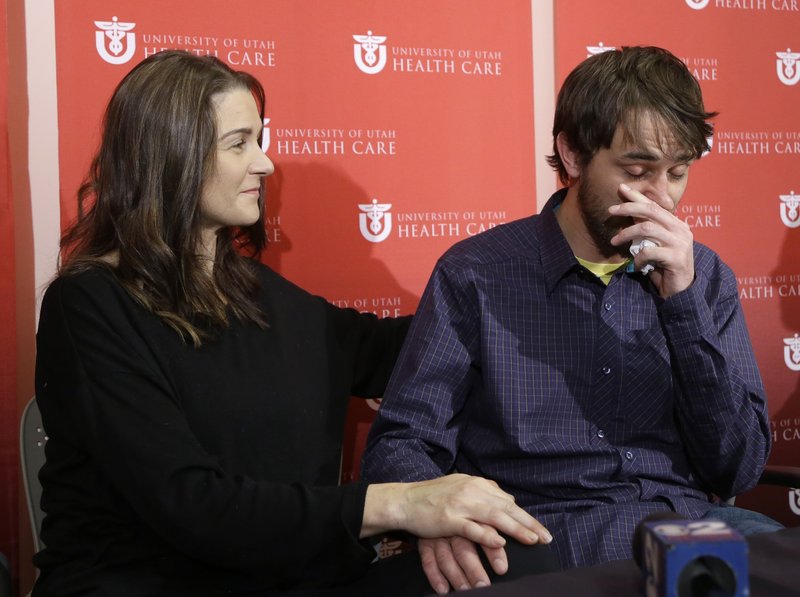 Elisabeth Malloy comforts her boyfriend, Adam Morrey, as he talks about their ordeal, at a news conference Wednesday at University Hospital in Salt Lake City.