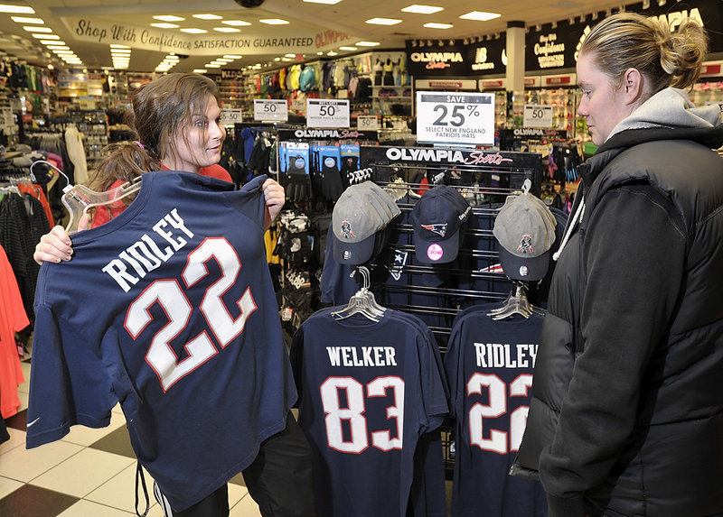 Olympia Sports manager trainee Jacqueline Bevier, left, helps regular customer Charissa Kennard from Conway, New Hampshire, explore the store's collection of Patriots souvenir clothing options at the Maine Mall store. Photographed on Wednesday, January 16, 2013.