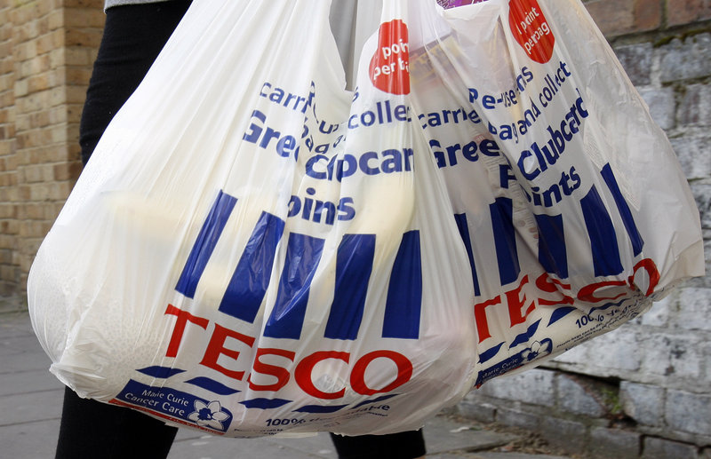 A shopper carries Tesco bags in London. An Irish food safety watchdog says it has found traces of horse DNA in burgers sold by some of the country’s biggest supermarkets.