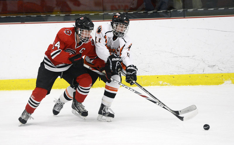 Trevor Murray of Scarborough, left, races Niklas Lemieux of Biddeford to the puck Thursday night. Scarborough improved to 9-1 by collecting its fourth straight shutout, winning 3-0 at the Biddeford Ice Arena.