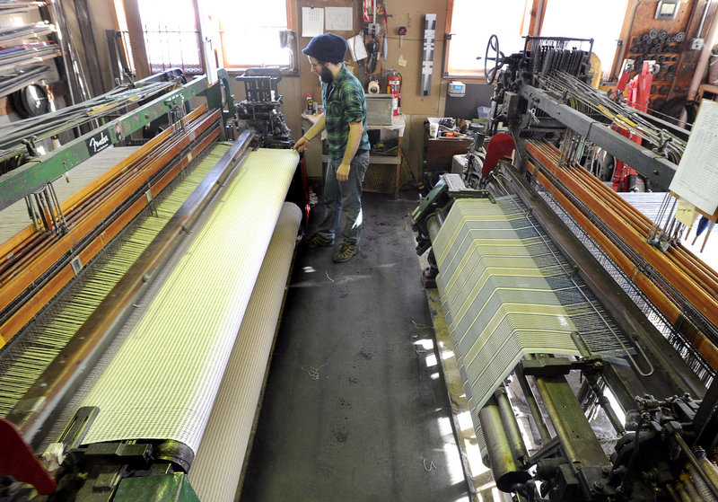 Ryan Benoit watches over two of the looms at the Brahms Mount factory.