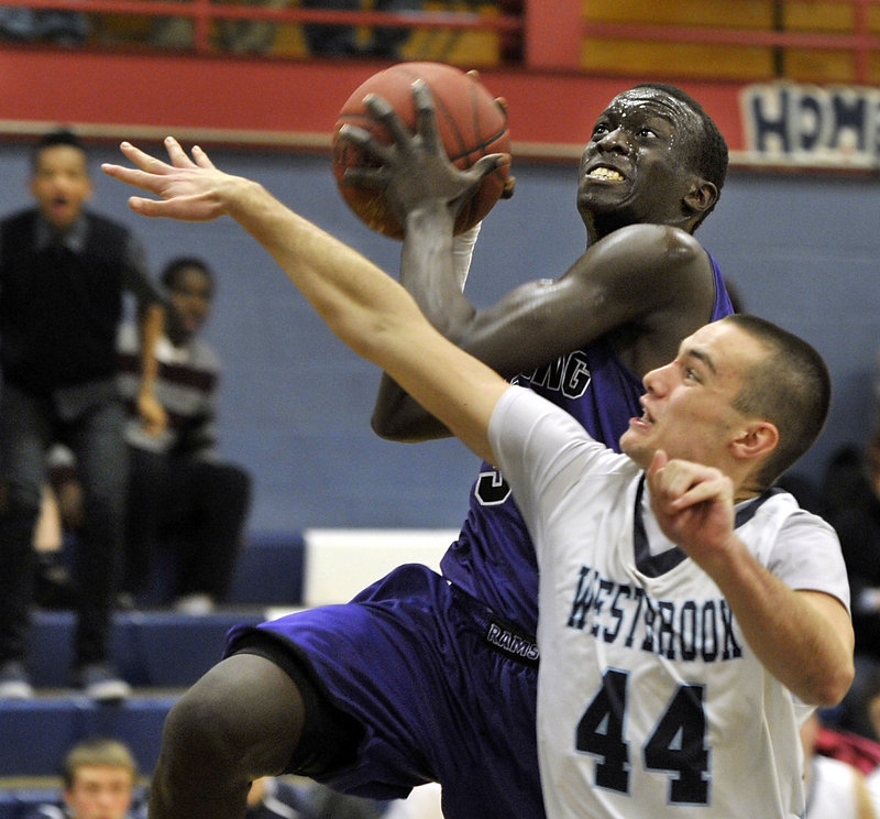 Labson Abwoch, who scored 18 points Friday night for Deering, heads to the basket against Noah Collins of Westbrook during visiting Deering’s 49-41 victory.