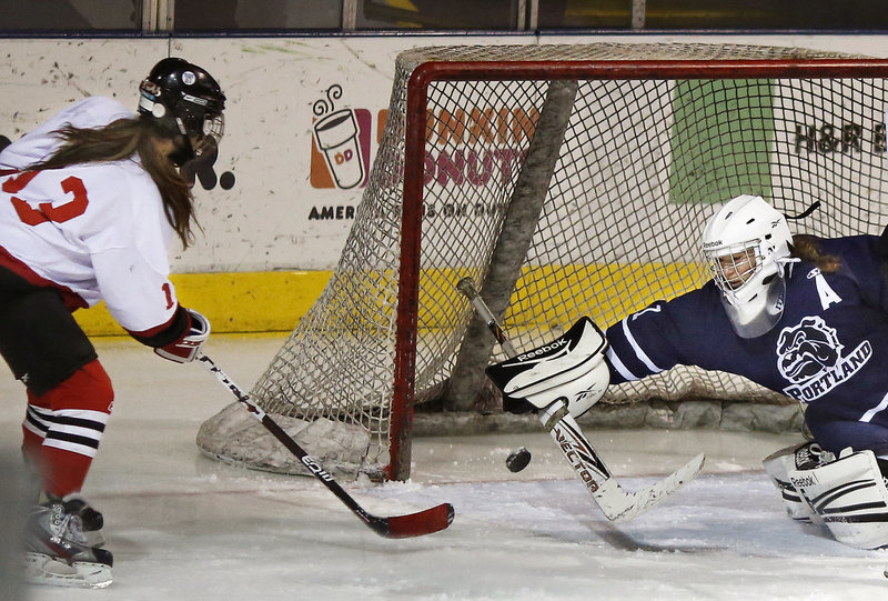 Madison O’Reilly of Scarborough sneaks the puck past Portland/Deering goaltender Leanne Reichert to score the final goal of the game Saturday as Scarborough came away with a 7-0 victory at the Cumberland County Civic Center.