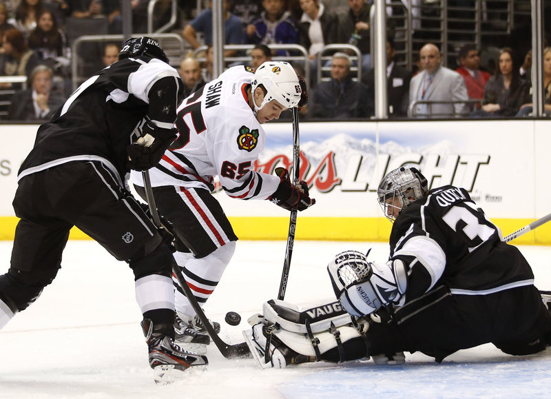 Chicago’s Andrew Shaw fights for a loose puck while Los Angeles goalie Jonathan Quick and Alec Martinez go for the clear. Chicago won, 5-2.