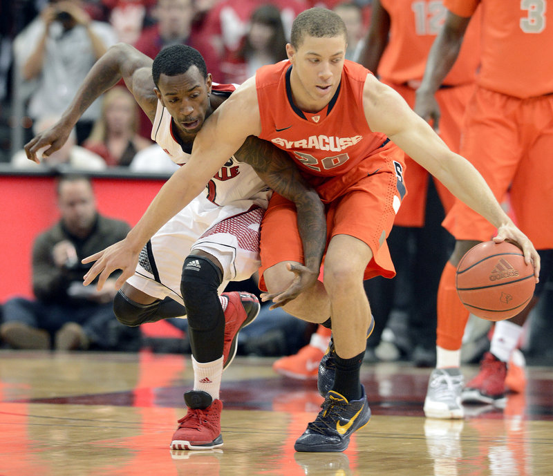 Brandon Triche of Syracuse protects the ball from Louisville’s Russ Smith during Saturday’s game at Louisville, Ky. Triche scored 23 points to help the Orange secure a 70-68 victory.