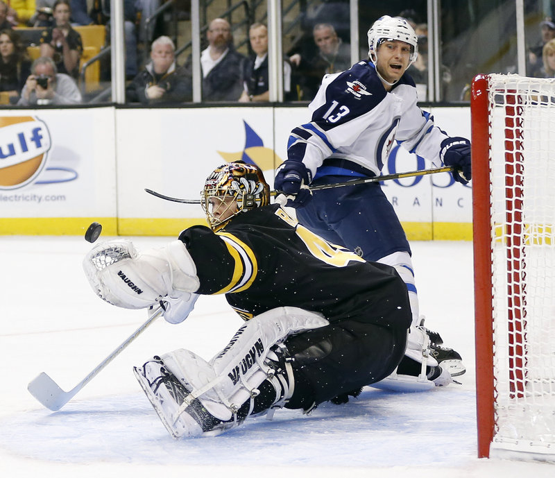 Bruins goalie Tuukka Rask does a split to make a glove save on Winnipeg’s Kyle Wellwood Monday. Rask finished with 26 saves.