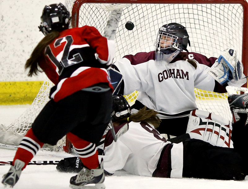 Hannah Snyder of Scarborough lifts a high shot over Gorham/Bonny Eagle goalie Maddy Hamblen to score the first goal of Monday’s girls’ hockey game at USM Ice Arena in Gorham. Scarborough won, 5-0.