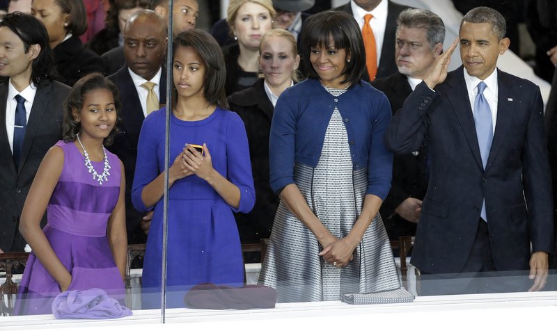 Michelle Obama, right, watches the inaugural parade Monday with daughters, Sasha, left, and Malia.