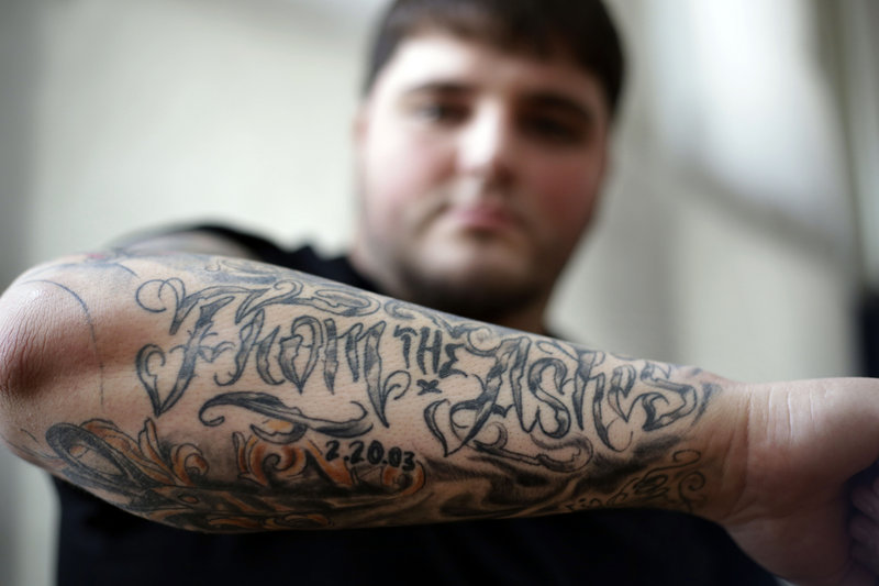 Alex Odsen of Cranston, R.I., displays a tattoo that honors victims of the 2003 nightclub fire in West Warwick, R.I. Odsen’s mother survived The Station blaze, where 100 died.