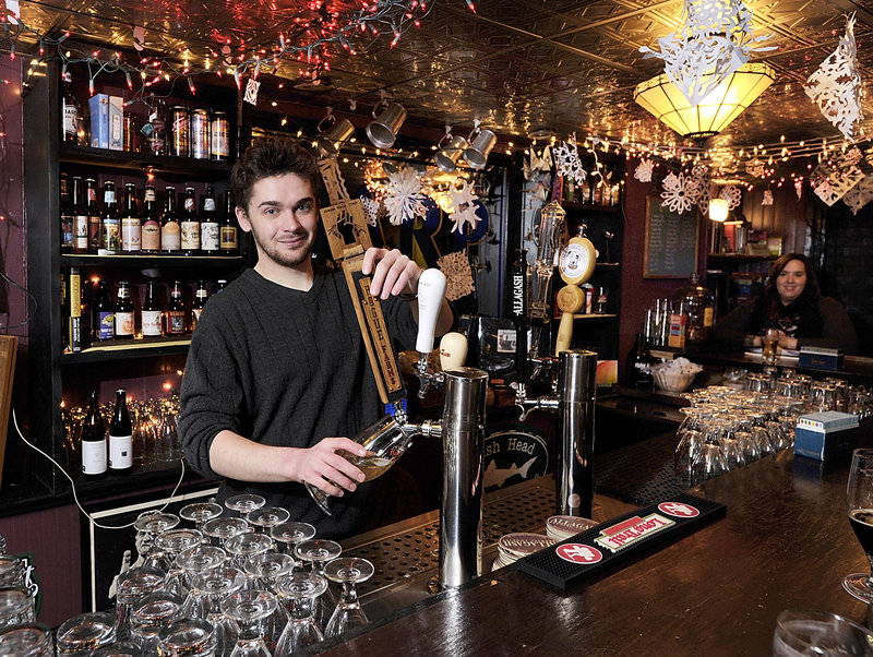 Assistant manager and bartender Thomas Henley draws a beer from one of six taps that feature Allagash Brewing beers, among others, at Mama’s CrowBar.