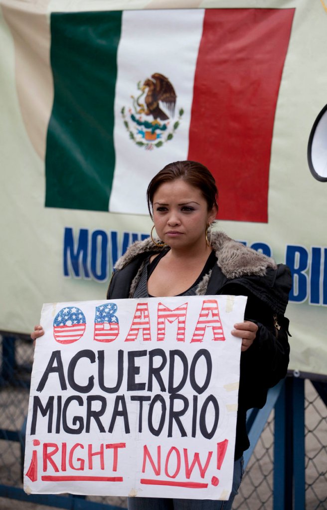 A migrants’ rights activist holds a sign that reads, in Spanish, “Obama, migration agreement right now!” outside the U.S. embassy in Mexico City.