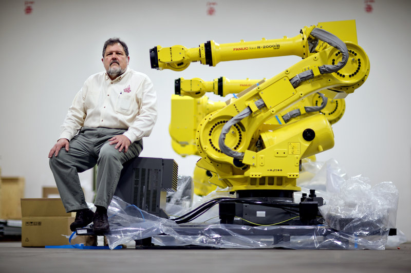 n this Jan. 15, 2013, photo, Rosser Pryor, Co-owner and President of Factory Automation Systems, sits next to a new high-performance industrial robot at the company's Atlanta facility. Pryor, who cut 40 of 100 workers since the recession, says while the company is making more money now and could hire ten people, it is holding back in favor of investing in automation and software. (AP Photo/David Goldman)