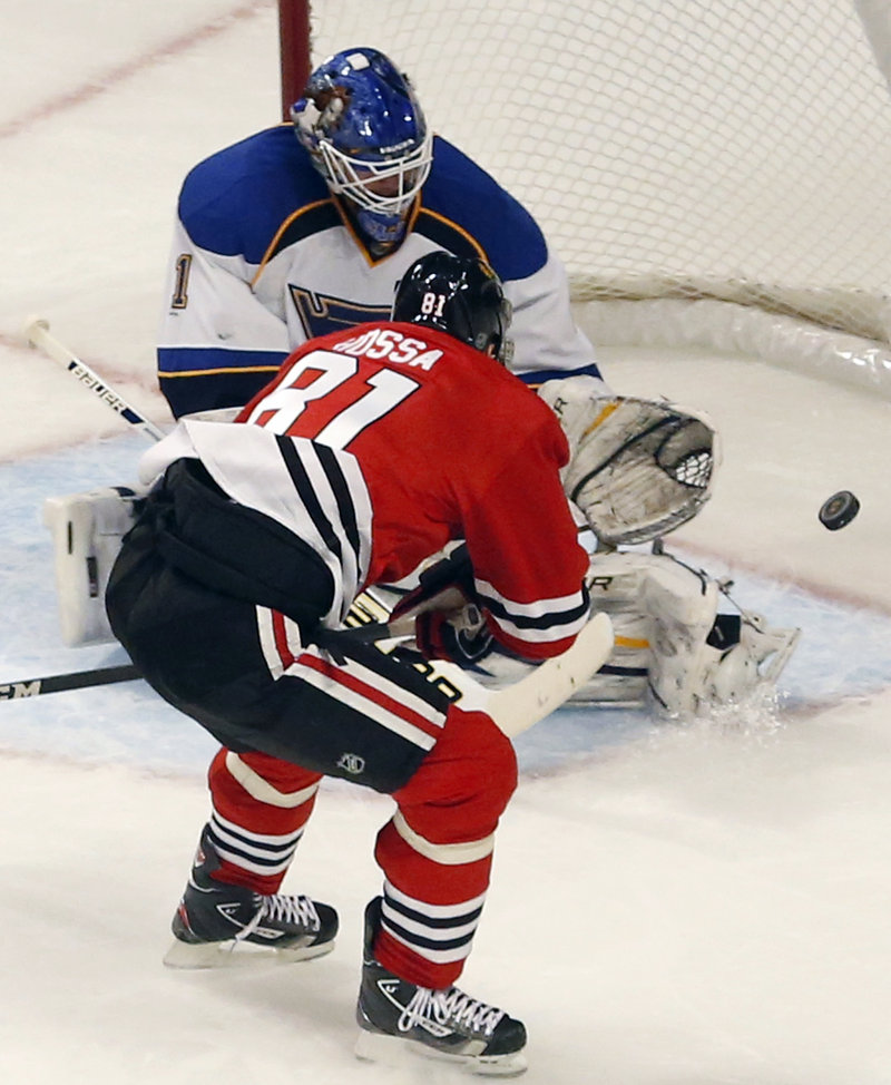 Blues goalie Brian Elliott makes a save on Chicago’s Marian Hossa in Tuesday night’s game at Chicago. The Blackhawks won, 3-2.