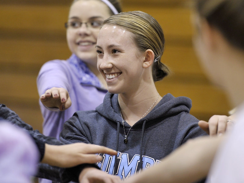 Charlotte Pierce joins her Thornton Academy teammates for a cheer before outdoor practice last week.