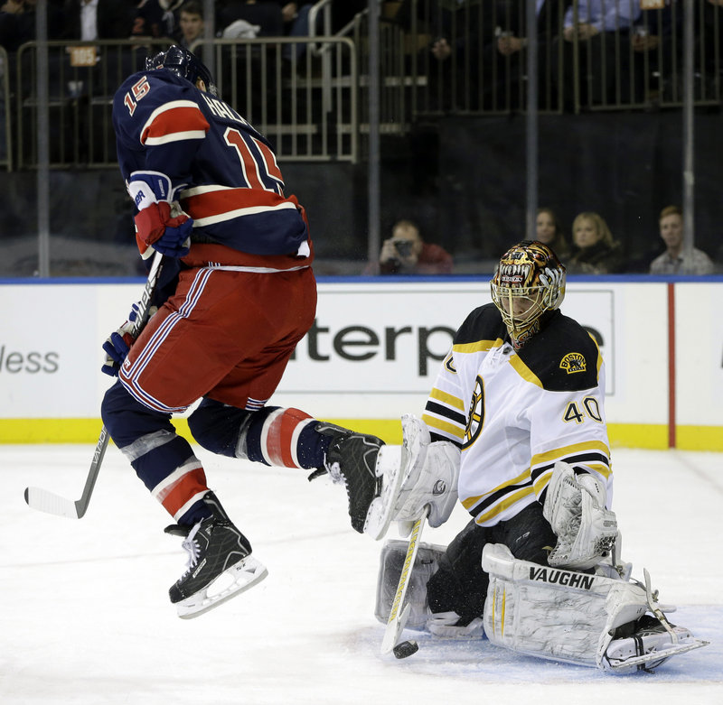 Jeff Halpern leaps to allow the puck to reach Bruins goalie Tuukka Rask, who made the second-period save Wednesday in New York. The Bruins lost for the first time this season.
